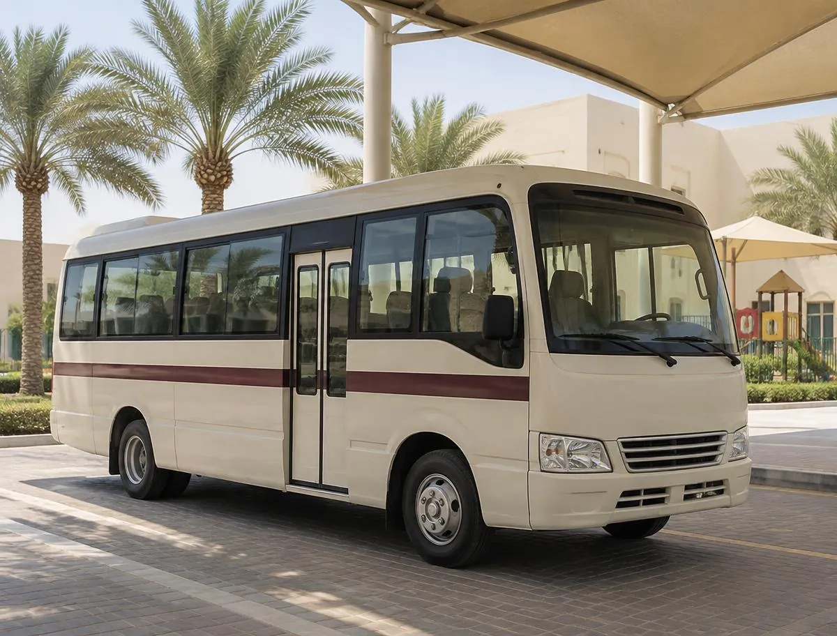 A cream school minibus parked in a shaded drop-off area.